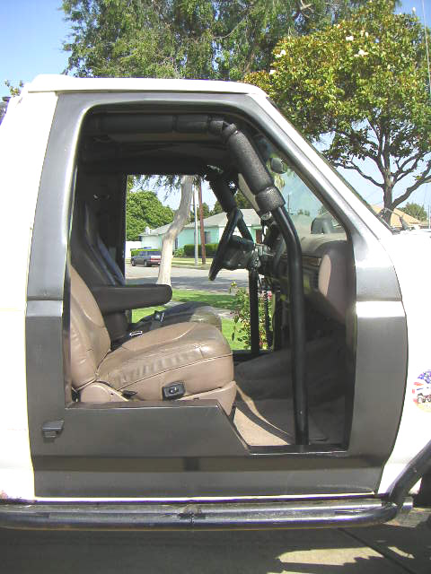 1996 Ford Bronco - Side view of a 1996 Ford Bronco's interior, tan seats and a roll cage.