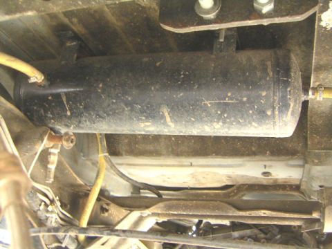 1996 Ford Bronco - A close-up view of the undercarriage of a vehicle, revealing an installed air tank and associated plumbing.