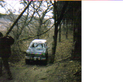1986 Ford Bronco - 1986 Ford Bronco navigating a wooded trail.