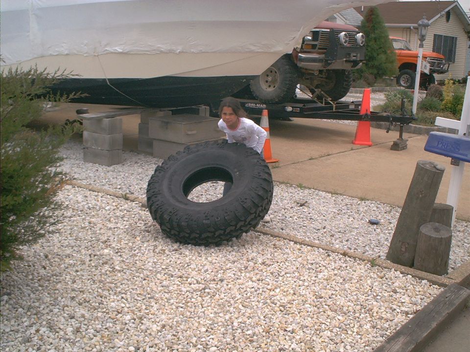 Red 1978 Ford Bronco on trailer, front view, partially obscured by boat cover