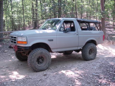 1995 Ford Bronco - This modified 1995 Ford Bronco is shown on a dirt path surrounded by trees.