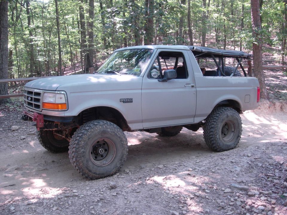 1995 Ford Bronco 3/4 front view, light color, off-road tires