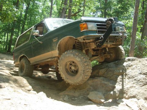 1995 Ford Bronco - This Ford Bronco is navigating a difficult rocky terrain on an off-road trail.