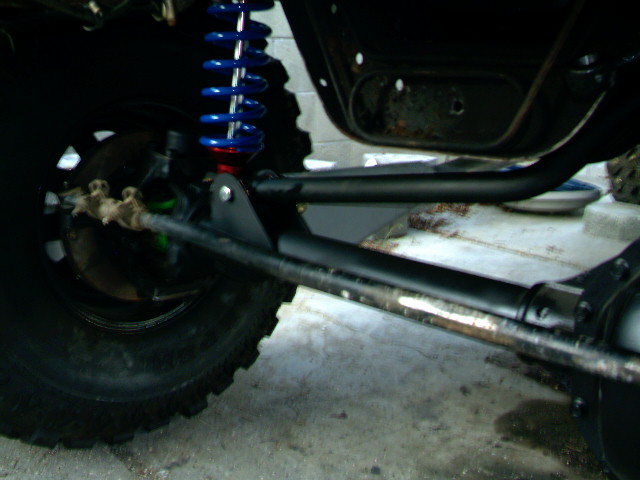 Close-up of off-road vehicle suspension with blue coilover shock and large tire