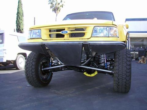1984 Ford Bronco - This yellow Ford pickup features a custom front bumper and a lifted suspension system.