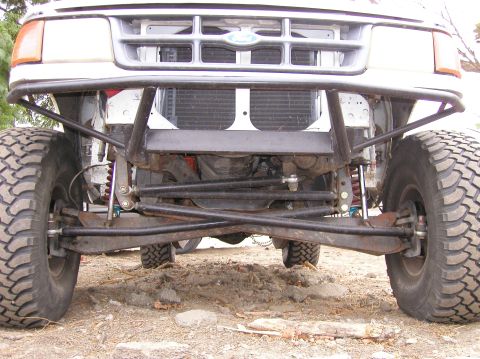 1984 Ford Bronco - Front view of an off-road truck's suspension and grille, modified for off-road use.