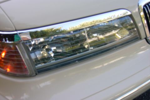 1996 Mercury Grand Marquis - Detail of a 1998 Lincoln Town Car's front end, showing the headlight and grille.