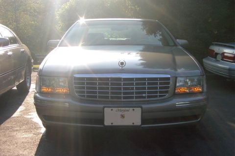 1996 Mercury Grand Marquis - Silver Cadillac sedan parked outdoors, showing its front grille and headlights.