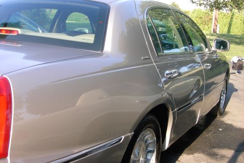 1996 Mercury Grand Marquis - The side profile of a Lincoln Town Car shows its distinctive rear window and chrome accents.