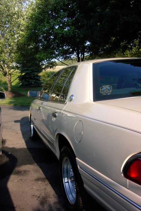 1996 Mercury Grand Marquis - Side profile of a 1996 Mercury Grand Marquis with a police sticker on the rear window.