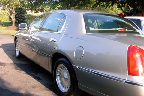 1996 Mercury Grand Marquis - The rear quarter panel and taillight of a silver sedan are visible.