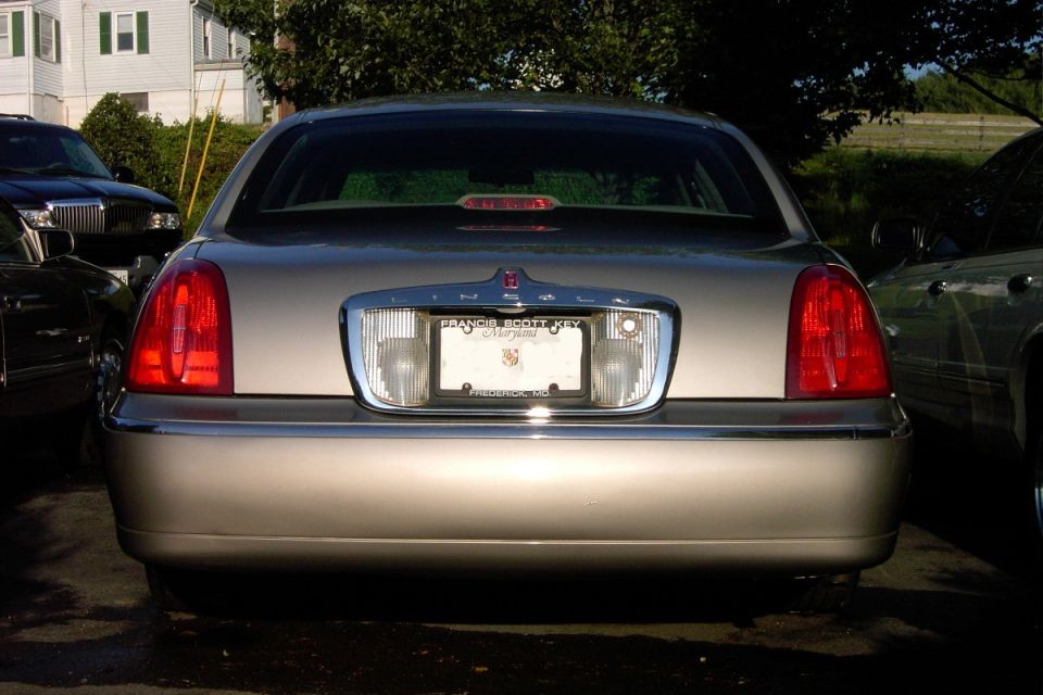 Rear of silver Lincoln Town Car sedan with Maryland plate frame, parked outdoors.