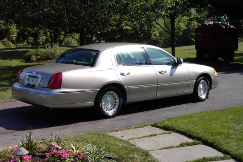 1996 Mercury Grand Marquis - A silver Lincoln Town Car is shown from a three-quarter front view on a paved driveway.