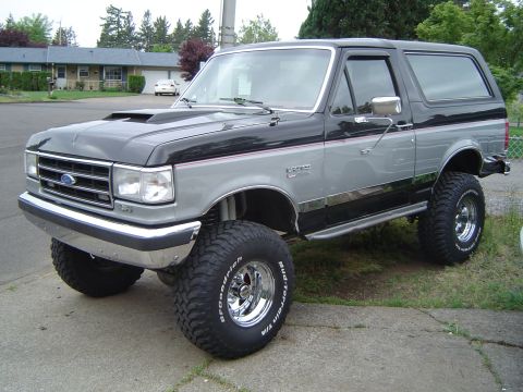 1989 Ford Bronco - This lifted Ford Bronco features a two-tone paint scheme and aggressive off-road tires, suggesting a model year earlier than claimed.