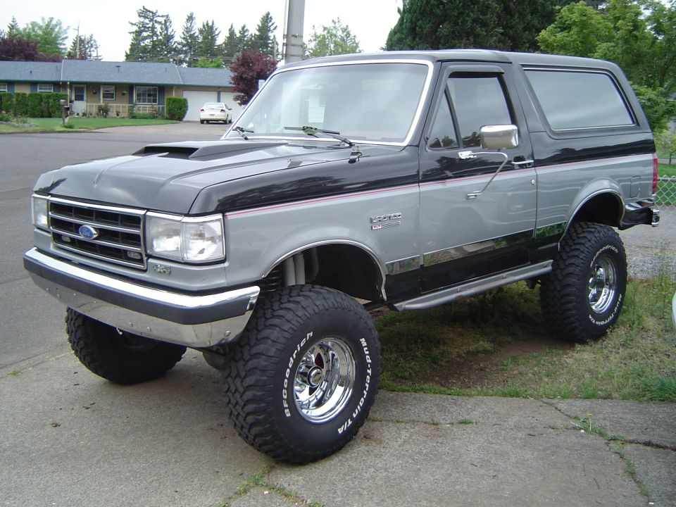 Lifted black and silver Ford Bronco XLT on BFG Mud-Terrain tires, front three-quarter view