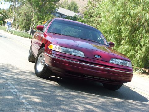 1992 Ford Crown Victoria - This 1992 Ford Crown Victoria is shown in a three-quarter front view, highlighting its red paint.