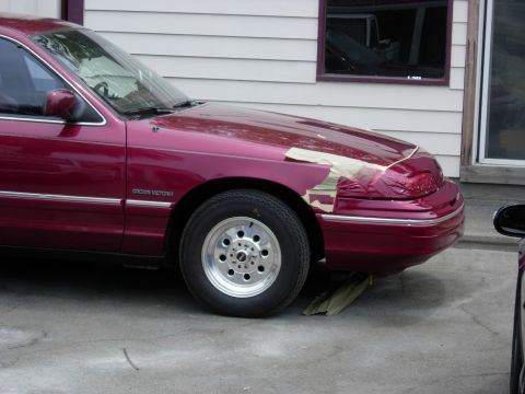 1992 Ford Crown Victoria - Maroon 1992 Ford Crown Victoria with taped front fender, likely awaiting new paint.