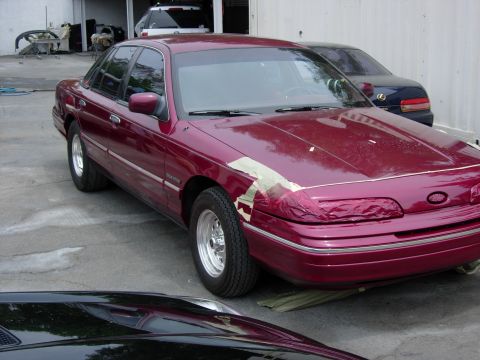 1992 Ford Crown Victoria - Maroon 1992 Ford Crown Victoria undergoing bodywork, with tape on the front end.