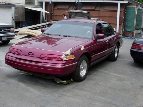 1992 Ford Crown Victoria - A maroon sedan is parked outside with its hood and fender taped up.