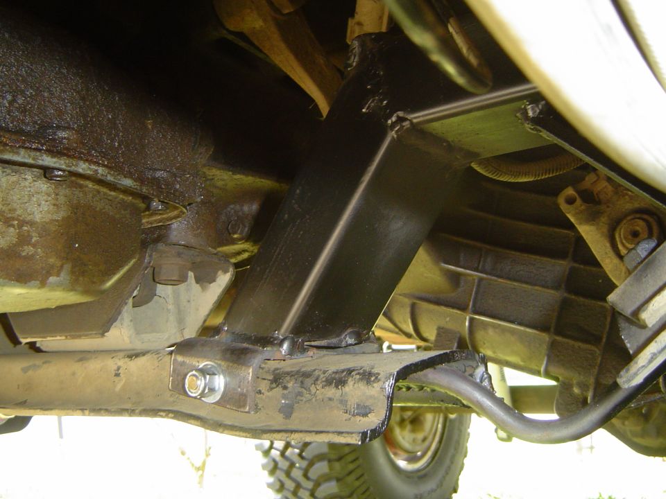 Undercarriage view of a truck transfer case, driveshaft and crossmember