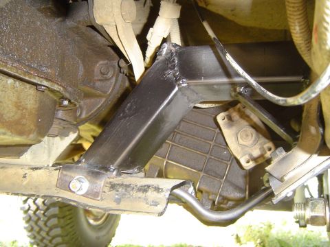 1989 Ford Bronco - Close-up view of a custom-welded bracket installed on the underside of a vehicle, likely for suspension modification.