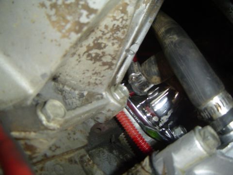 1989 Ford Bronco - Close-up view of a chrome engine part with associated hoses and tubing.