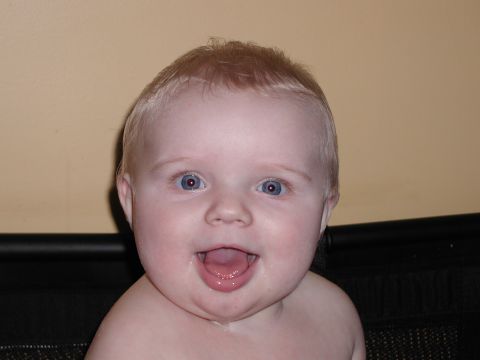 1998 Jeep TJ - A baby with wide blue eyes and blond hair is shown with its mouth open in a happy expression.