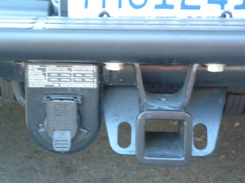 2004 GMC Sierra 1500 - Close-up of a trailer hitch receiver and its associated electrical connector.