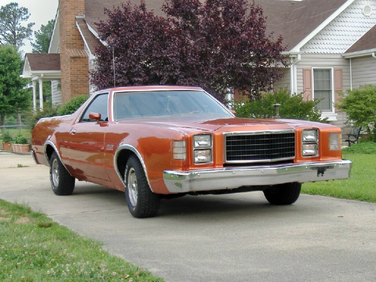 Orange Ford Ranchero coupe-utility parked in a driveway, front three-quarter view.