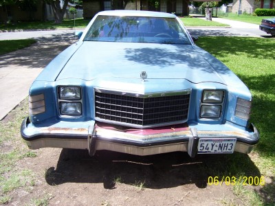 1972 Ford Ranchero - This light blue vehicle, identified as a 1972 Ford Ranchero, is shown from the front, highlighting its chrome grille and square headlights.