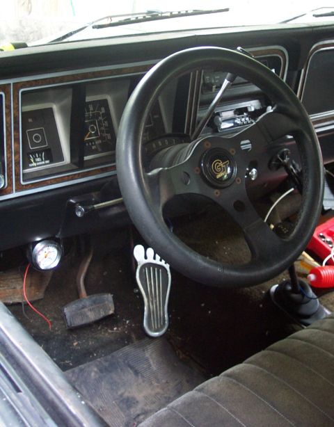 1978 Ford Bronco - Interior view of a 1978 Ford Bronco, an aftermarket steering wheel and a unique foot-shaped gas pedal.