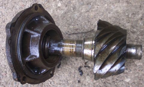 1978 Ford Bronco - A close-up view of a differential pinion gear and its associated housing, resting on a concrete surface.