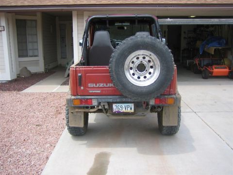 1987 Suzuki Samurai - A red Suzuki Samurai is parked in a driveway with a garage in the background.