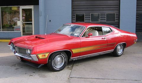 1972 Ford Ranchero - This 1972 Ford Ranchero is parked in front of a building with a large garage door.