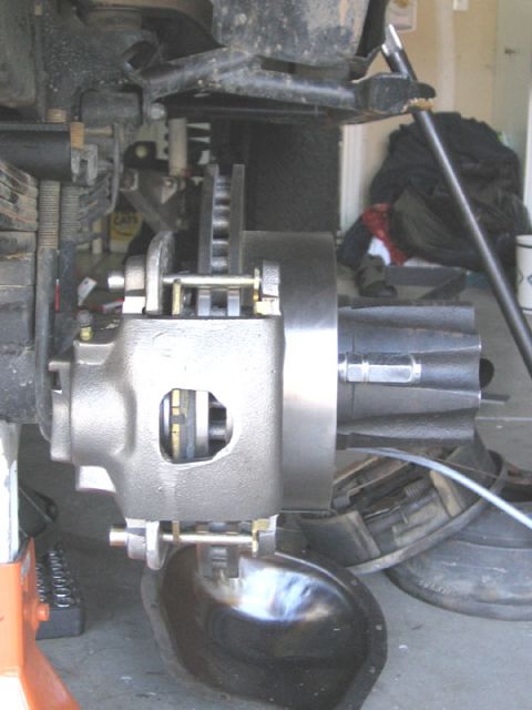 1994 Ford Bronco - The vehicle is on a jack stand, and a pan is placed underneath to catch fluid from the brake system.