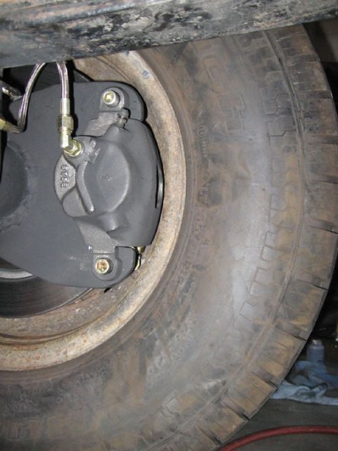 1994 Ford Bronco - Close-up view of a vehicle's disc brake caliper and tire assembly.
