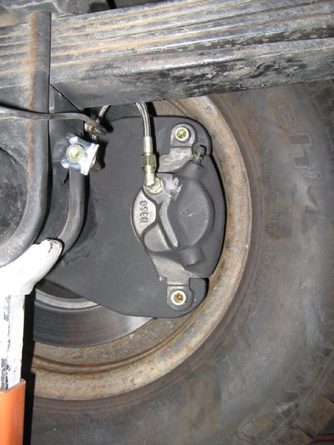 1994 Ford Bronco - Close-up view of a rear disc brake caliper, showing the part number 'STEE'.