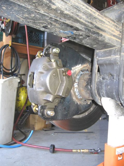 1994 Ford Bronco - Close-up of a vehicle's rear disc brake assembly, showing the caliper and rotor.
