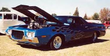 1972 Ford Ranchero - Customized 1972 Ford Ranchero pickup truck with flame decals and a prominent engine displayed under the open hood.