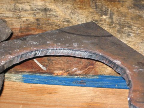 1994 Ford Bronco - A metal component shows the results of a cutting process, with distinct machining marks along the curved edge.