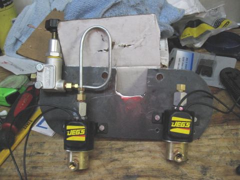 1994 Ford Bronco - A JEGS fuel solenoid kit is shown mounted on a metal plate, a Wilwood regulator and braided fuel lines.