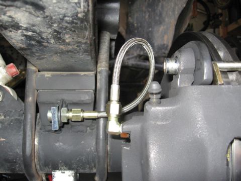 1994 Ford Bronco - Detail of a vehicle's brake system, showing the caliper and brake line connection.