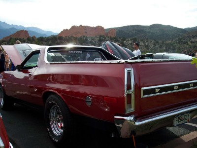1972 Ford Ranchero - Red 1972 Ford Ranchero at a car show with the hood up, mountains visible behind.