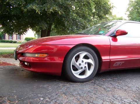 1996 Ford Probe - This red 1996 Ford Probe GT is captured in a 3/4 front view, highlighting its unique design and GT badging.