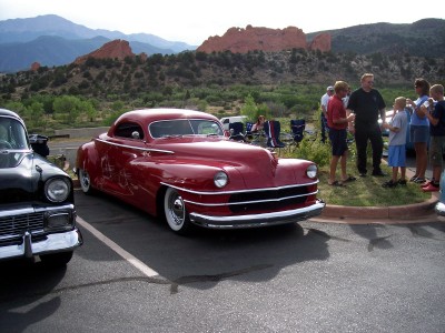 1972 Ford Ranchero - A red coupe is parked at an outdoor event with people gathered around.