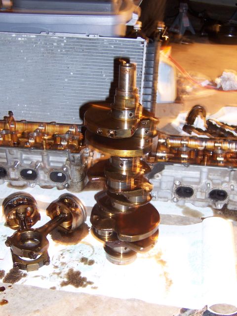 1996 Ford Probe - Disassembled engine components, including a crankshaft and pistons, are laid out on a surface, likely for repair or inspection.