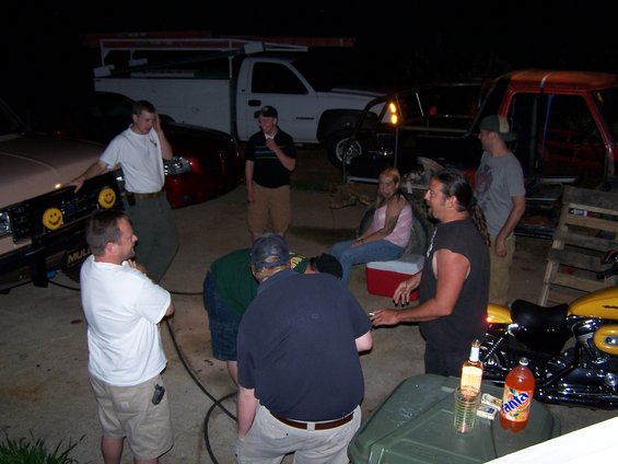 Beige truck front with yellow smiley face lights and people gathered