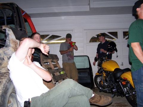 1995 Ford Bronco - Several people are in a garage with a yellow motorcycle and parts of a large vehicle.
