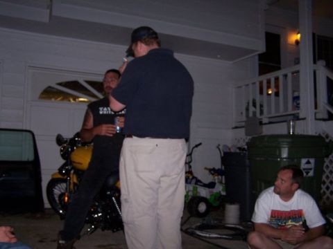 1995 Ford Bronco - A group of people gather around a motorcycle in a driveway at dusk.