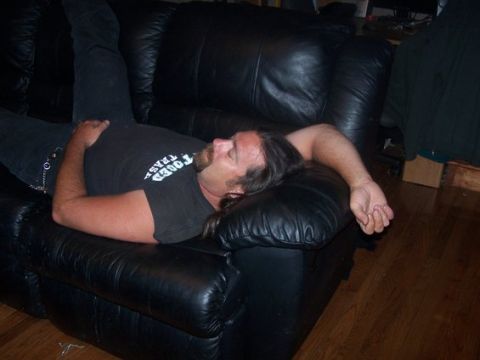 1995 Ford Bronco - Man sleeping on a black leather couch.